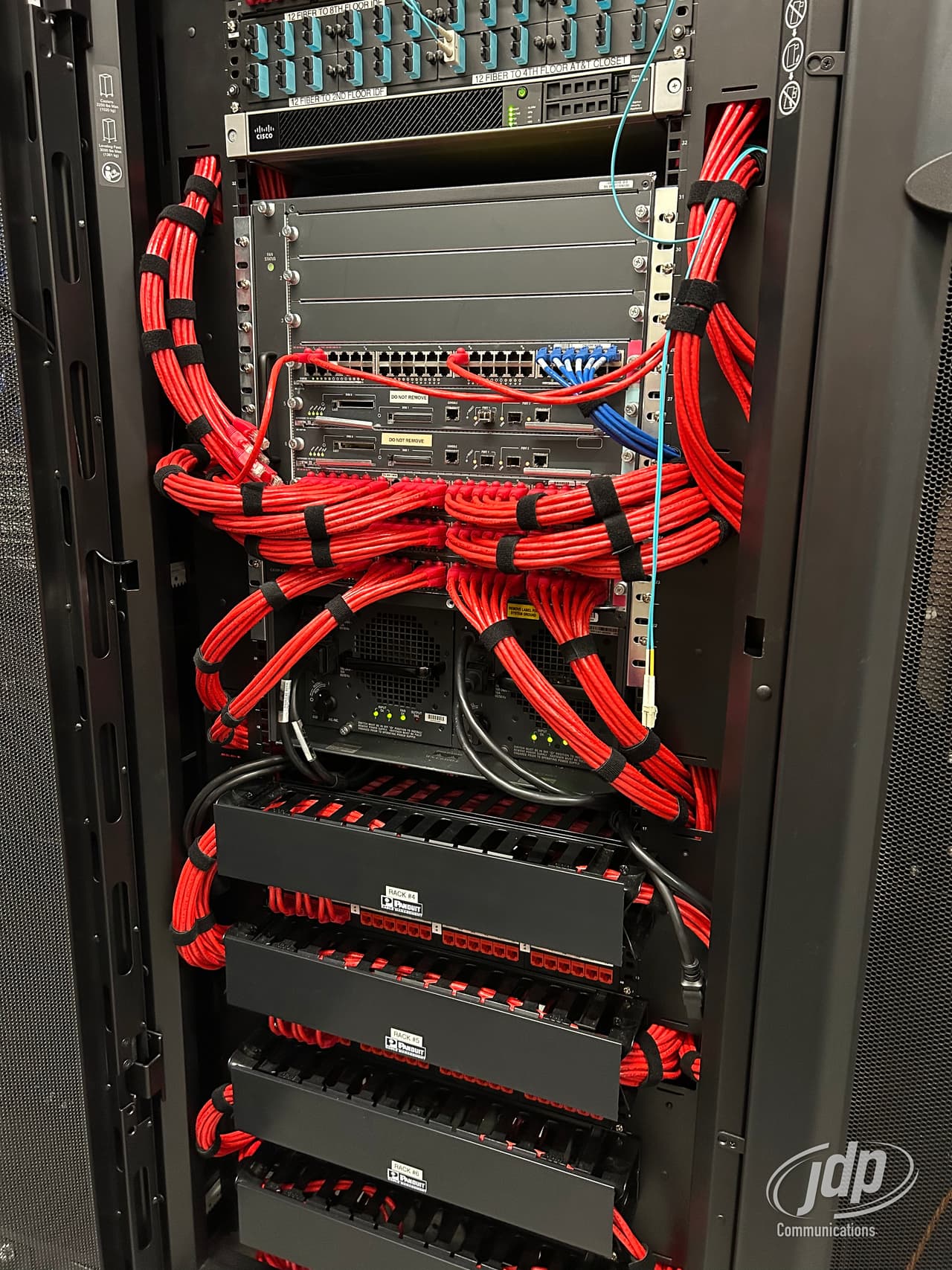 Red patch cords dressed across a live network rack